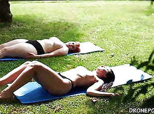 Two naked girls sunbathing in the city park