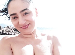 Brunette girl masturbates on public beach